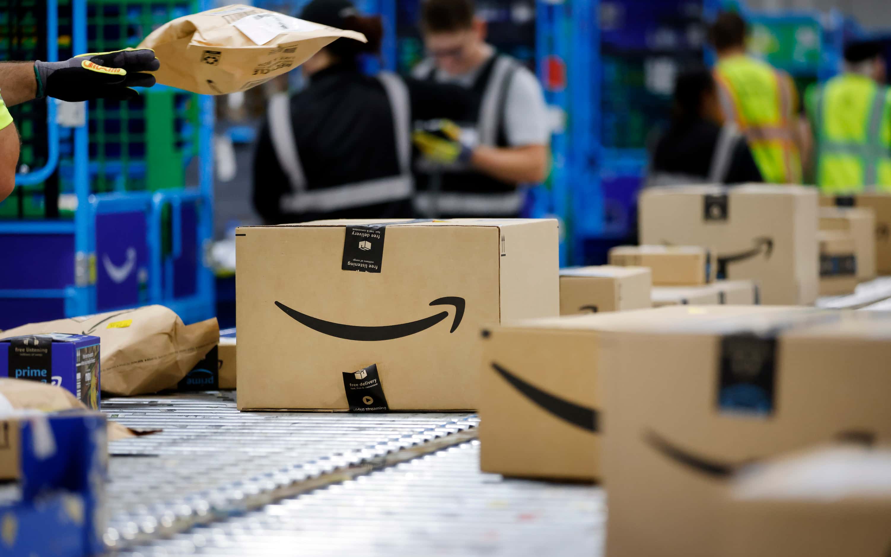 PRIME day deal packages move along the conveyor belts after being sorted off of trucks at...
