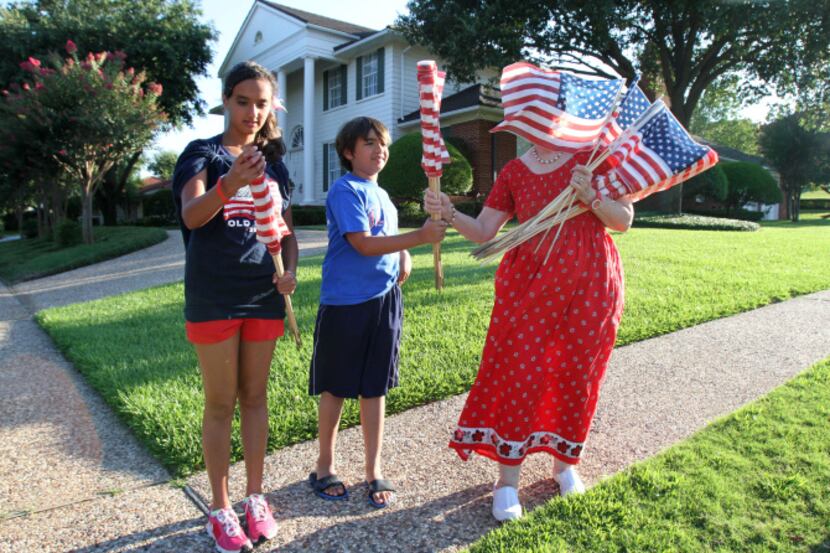 Sally Grantvedt braved a gust of wind Sunday as young volunteers Alisha and Kaden Nathani...