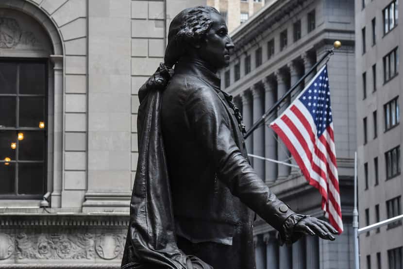 A statue of George Washington is near the New York Stock Exchange building along Wall Street...