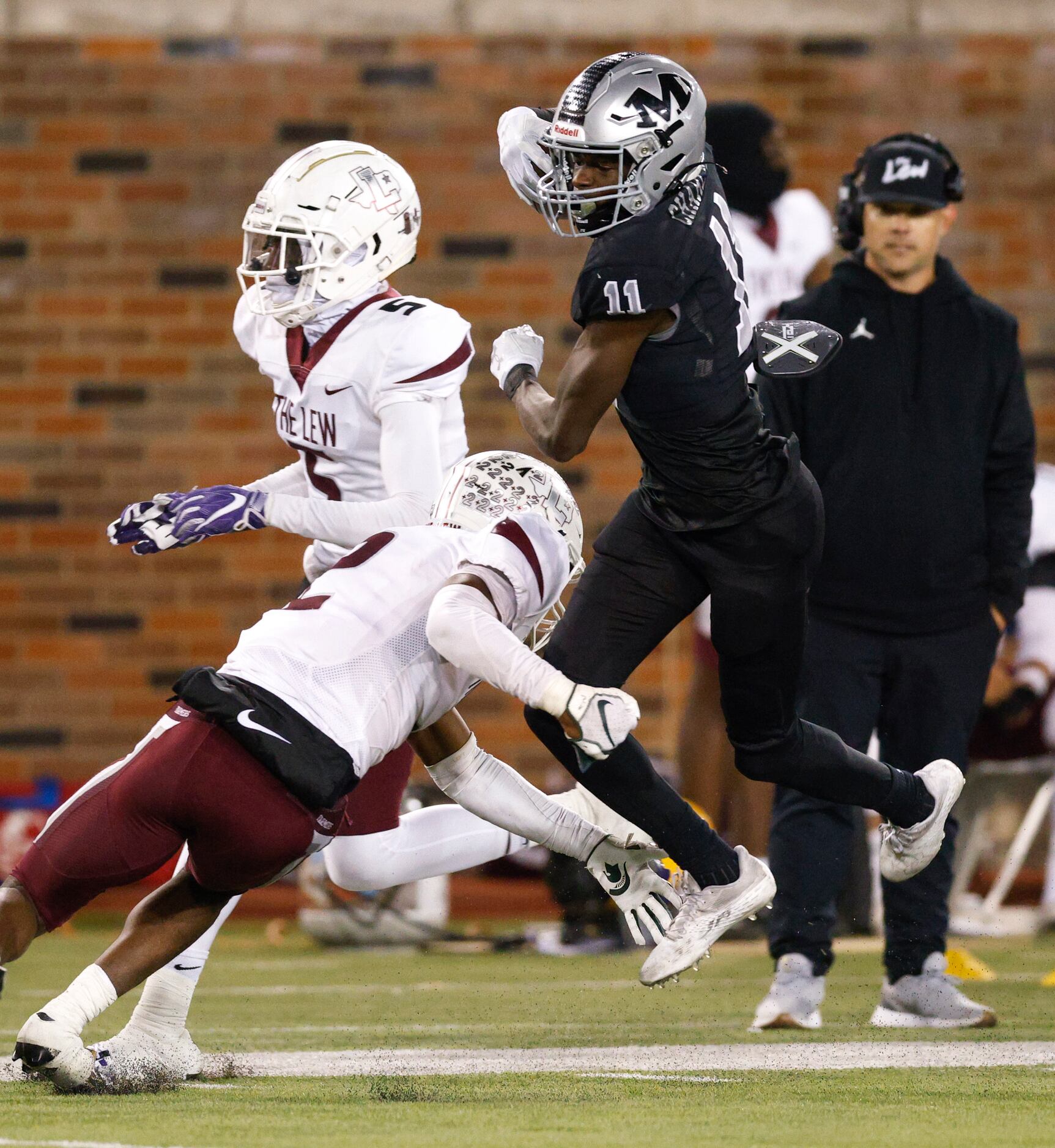 Arlington Martin wide receiver Jeremiah Charles (11) jumps around a tackle from Lewisville...