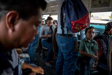 Edgar Yovani Monjel (izq.) y su hijo Cristopher, de 7 años, en Juárez, abordo de un autobús...