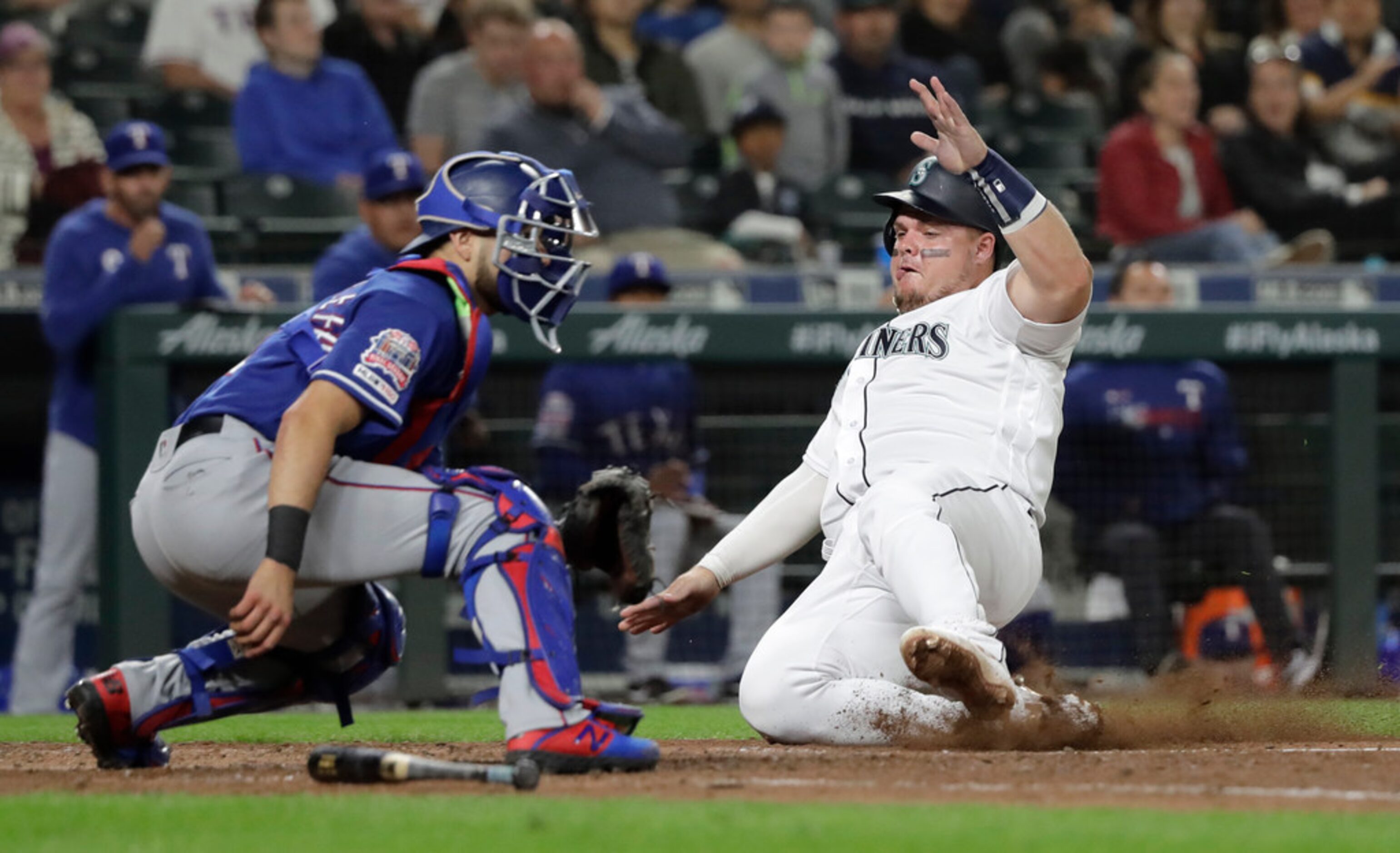 Seattle Mariners' Daniel Vogelbach, right, slides to score a run on a single hit by J.P....