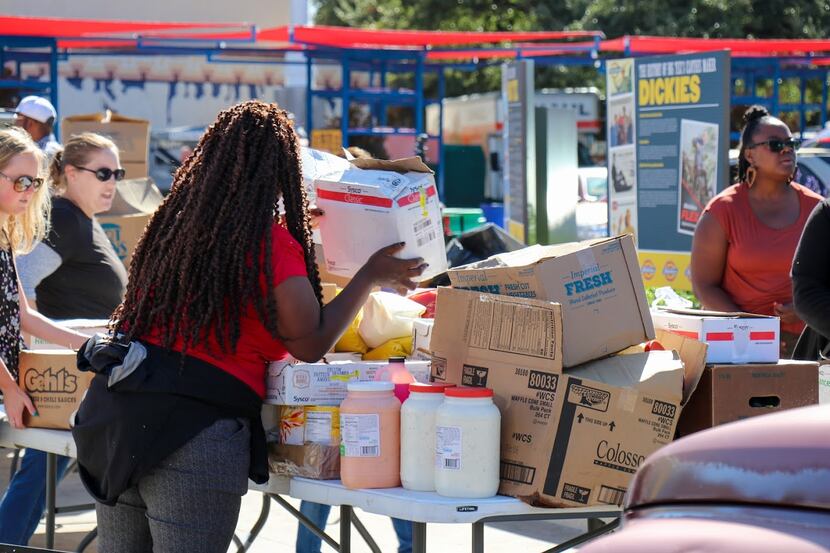 Volunteers at the State Fair of Texas sort through boxes and containers of donations for...