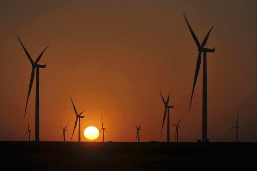 Turbines turn slowly at sunset at a wind farm near the town of Panhandle, Texas, July 10,...