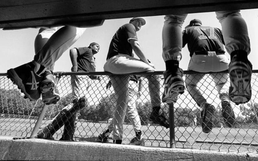 The Dallas Sox gather around their dugout, awaiting the start of their game. Staff...