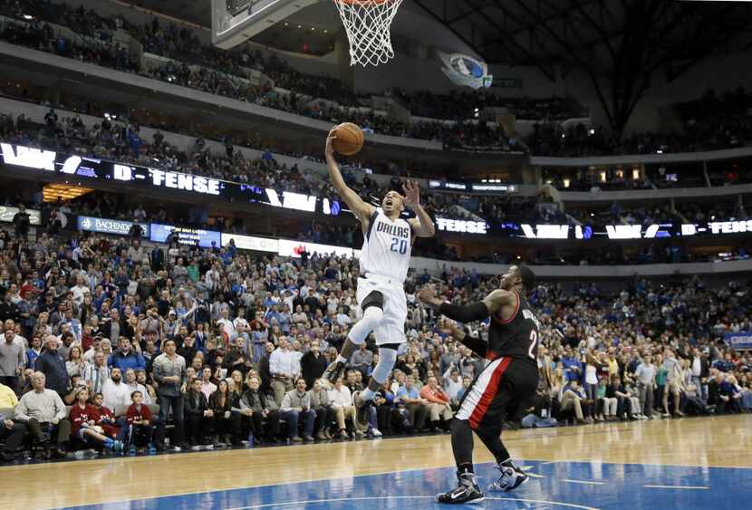 Dallas Mavericks' Devin Harris (20) leaps to the rim over Portland Trail Blazers' Wesley...