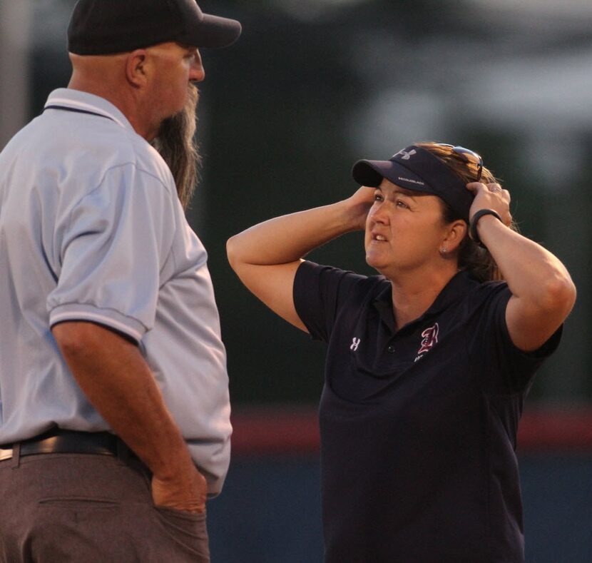 Richland head coach Brenda Jacobson inquires into a ruling with the field umpire during a...