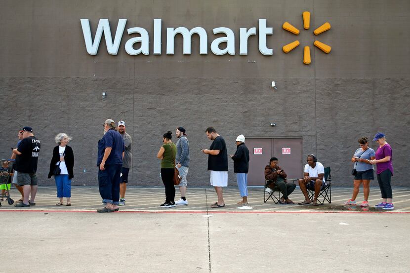 A line stretches across the front of the Wal-Mart in Pearland on Wednesday as people wait...