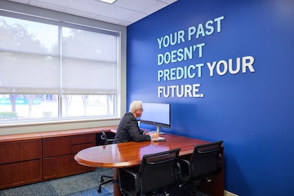 Man sitting at a desk in an office space.