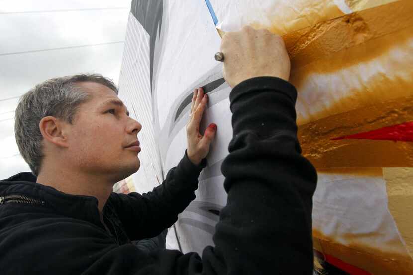 Graphic artist Shepard Fairey worked on painting a mural titled "Harmony" on the building at...