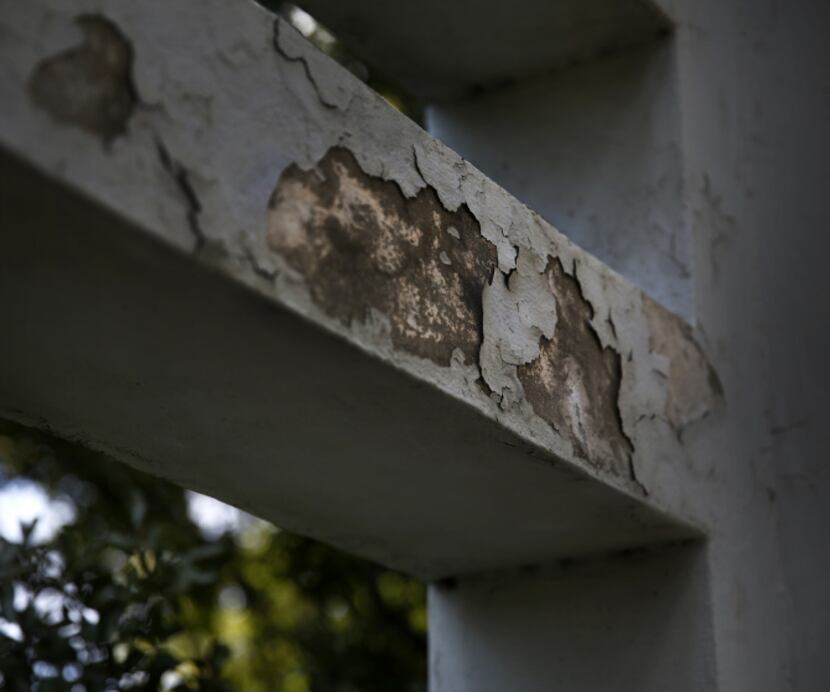 Chipped paint and cracked plaster can be seen on the south pergola in Dealey Plaza.
