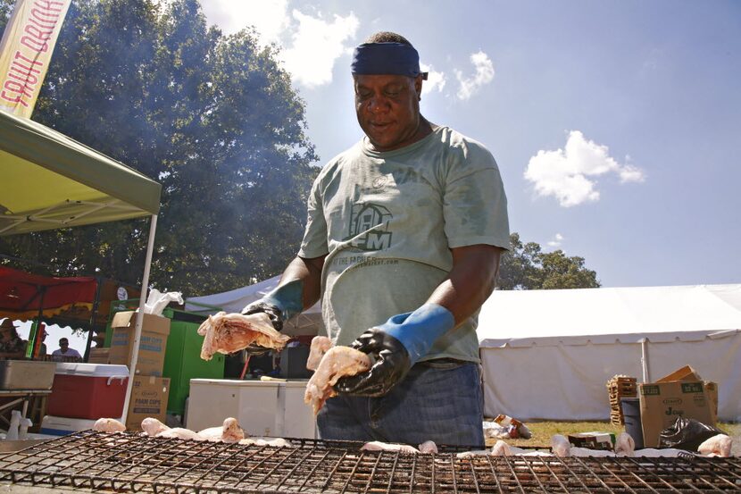 Maurice Aldridge with Metro Portapit loads a rack of chickens to the smoker during a...