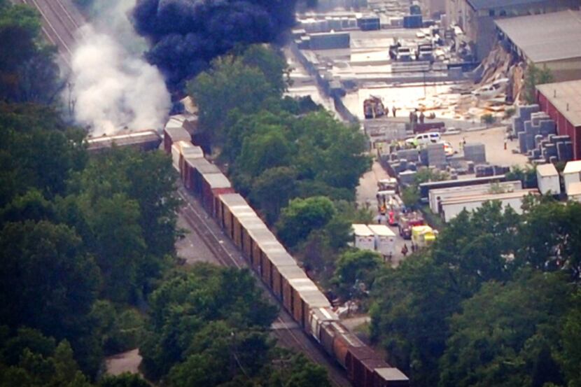 Plumes of smoke billowed from burning train cars after a CSX freight train hit a trash truck...