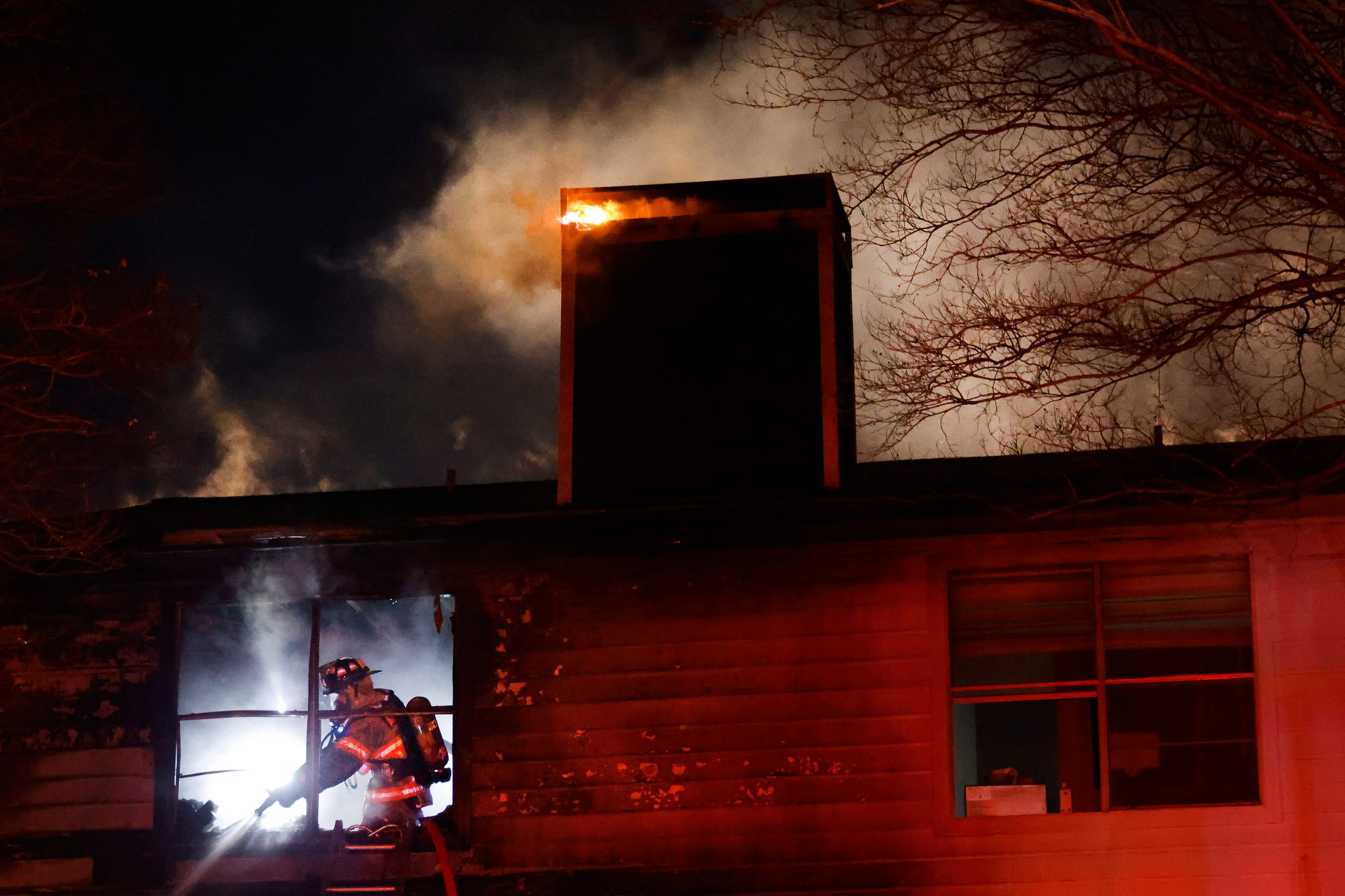 Arlington firefighters put out hot spots as they battle a two-alarm blaze at the Rise North...