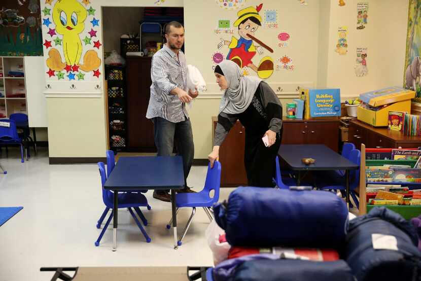 Samer Elsaadi (left) and his wife, Fawzia Adi Elsaadi, rearrange a classroom after staying...