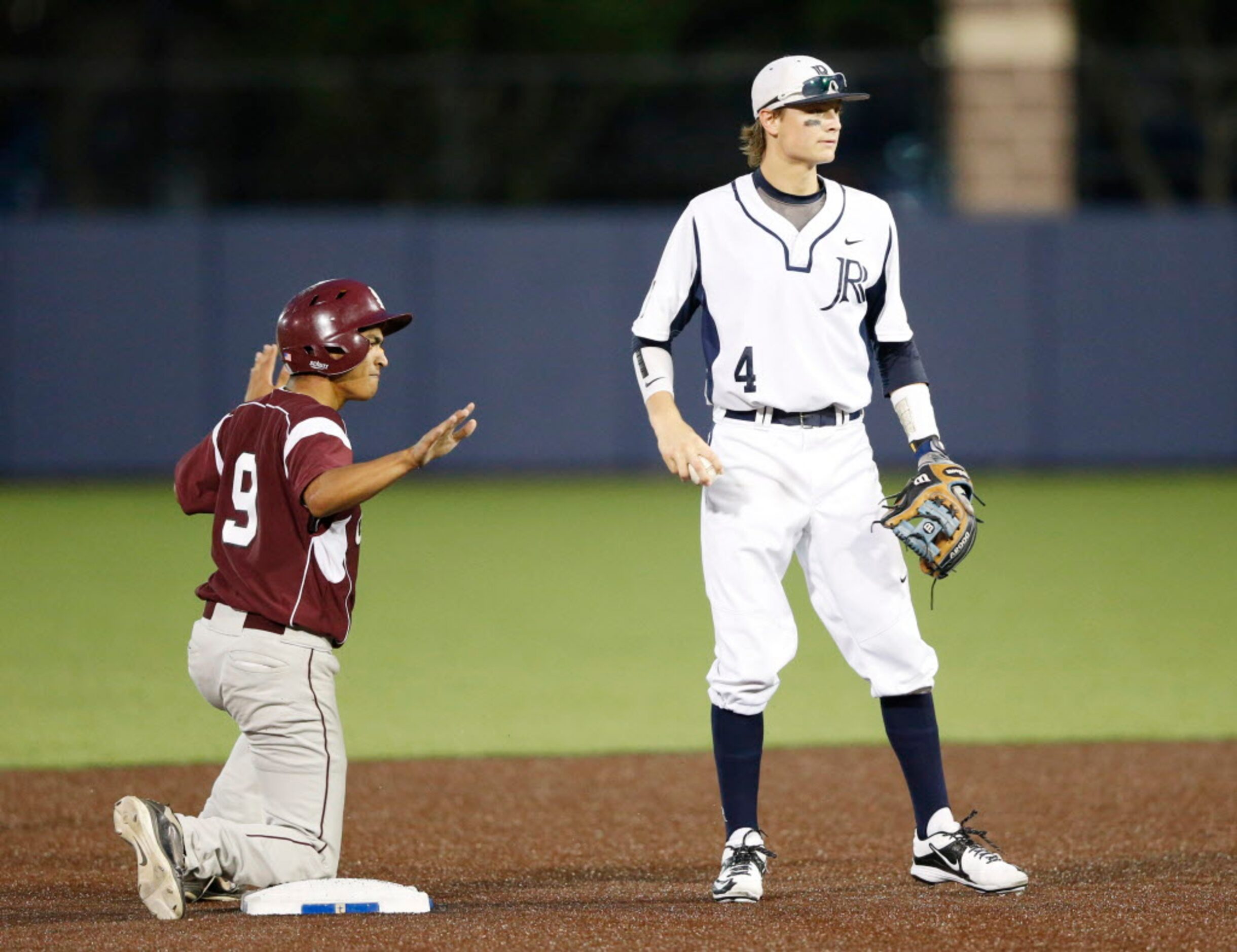 Mesquite's Isaiah Pelayo (9) is safe despite an attempt from Jesuit's Cameron Dobbs (4) in...