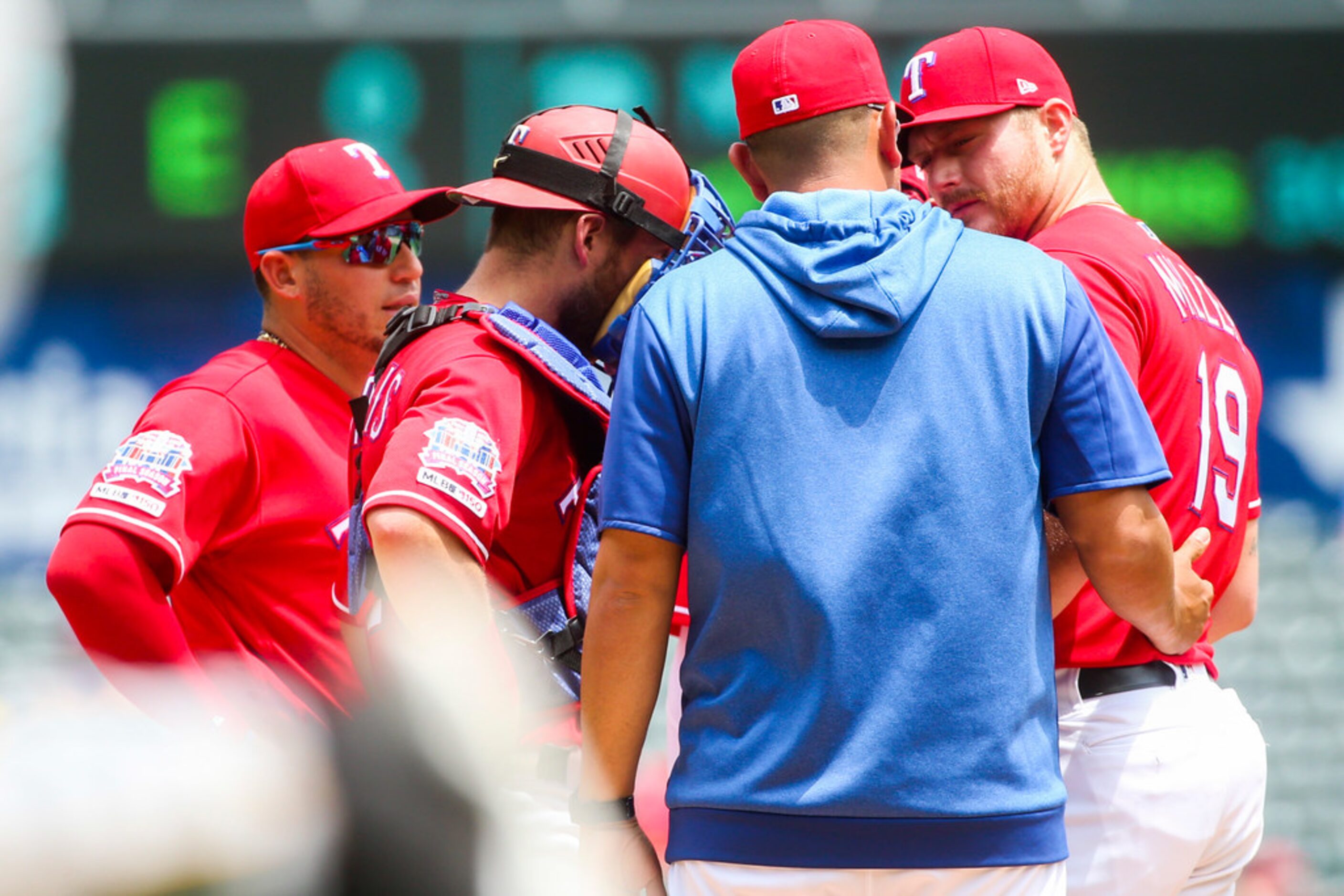 Texas Rangers pitching coach Julio Rangel (blue) talks to starting pitcher Shelby Miller...