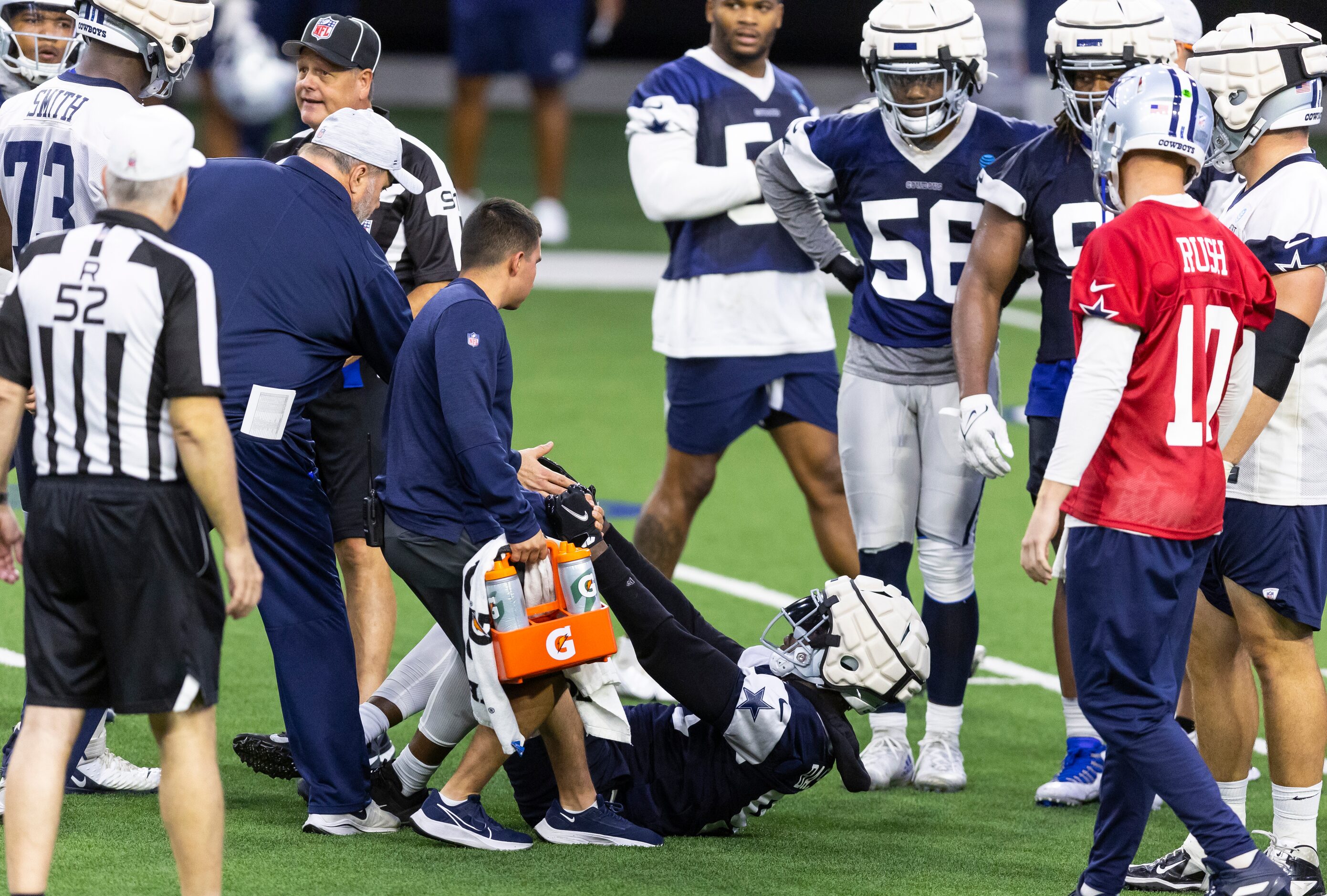 Dallas Cowboys defensive end Tarell Basham (93) is helped up by head coach Mike McCarthy and...