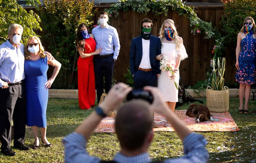 Photographer Carter Rose snaps a photo of the wedding party, including the newlyweds Dana...