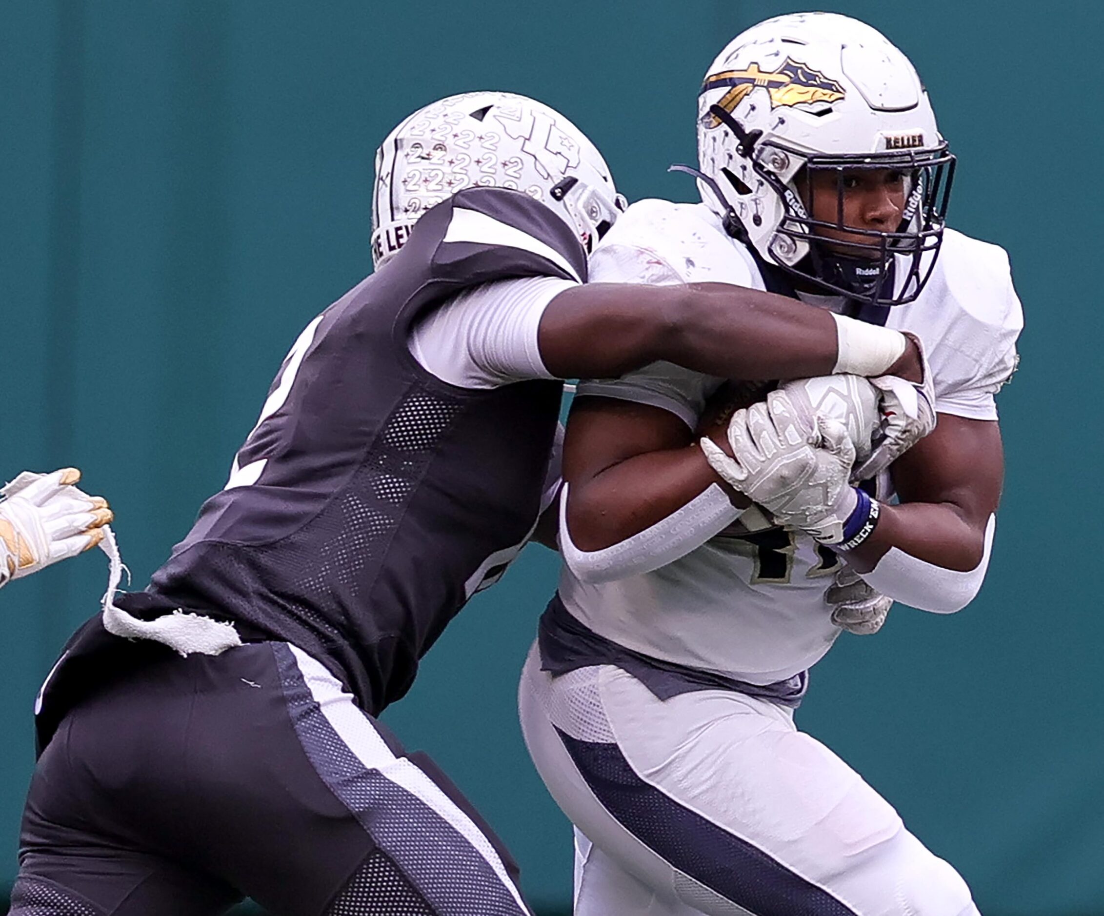 Keller running back Jayden Hart, (right) get stopped for a short gain against Lewisville...