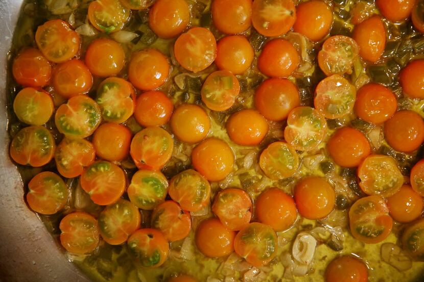 Pickled jalapeño, Sun Gold cherry tomatoes and garlic cook in a pan at the home of Julian...