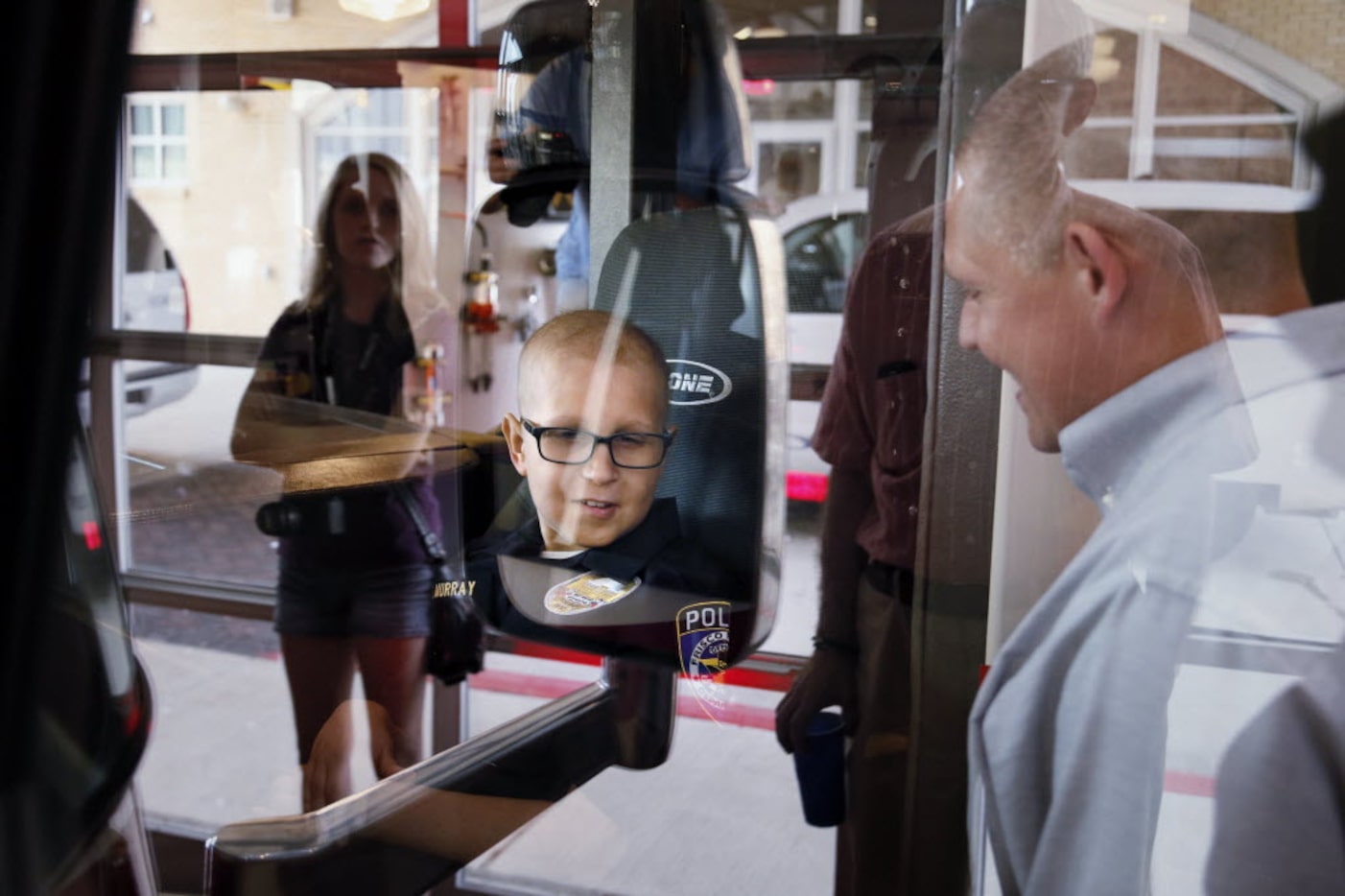 Ten-year-old Kyle Murray, of Frisco, smiles as he sits on a displayed fire truck while he...