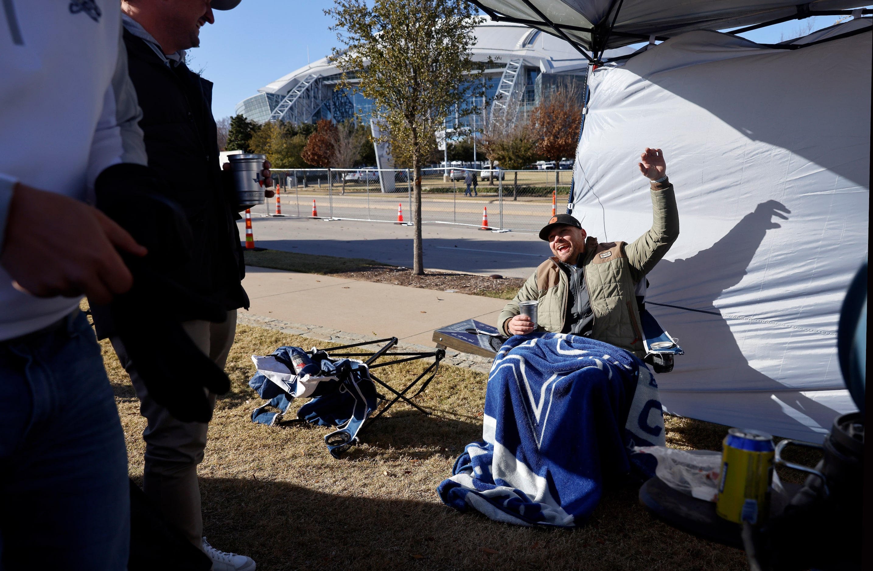 Dallas Cowboys fan Russell Eustace of Edmond, Oklahoma found a warm spot in the sun as he...