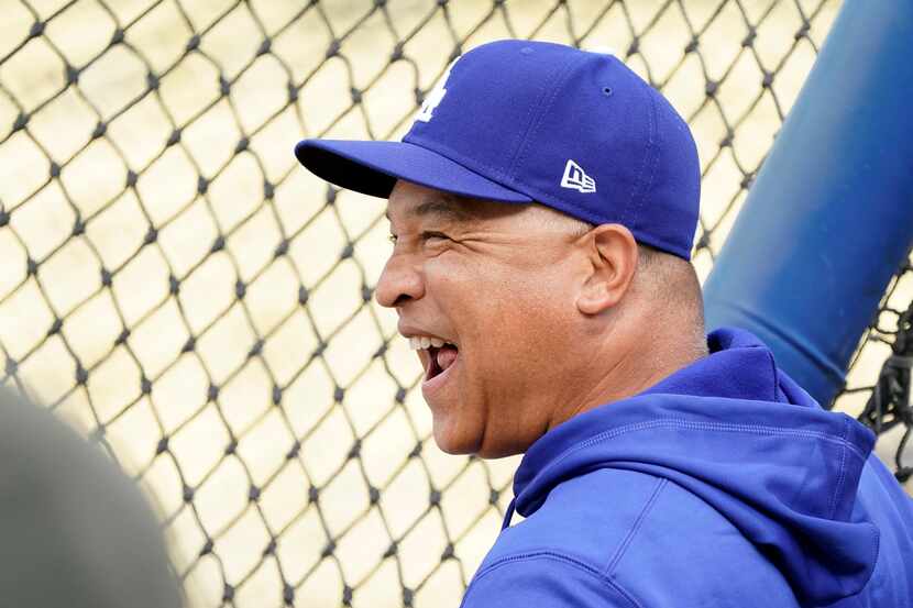 Los Angeles Dodgers manager Dave Roberts laughs during batting practice prior to Game 1 of a...