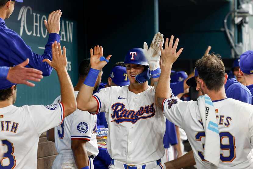 Texas Rangers third baseman Josh Jung (6) celebrates his two-run home run in the dugout...