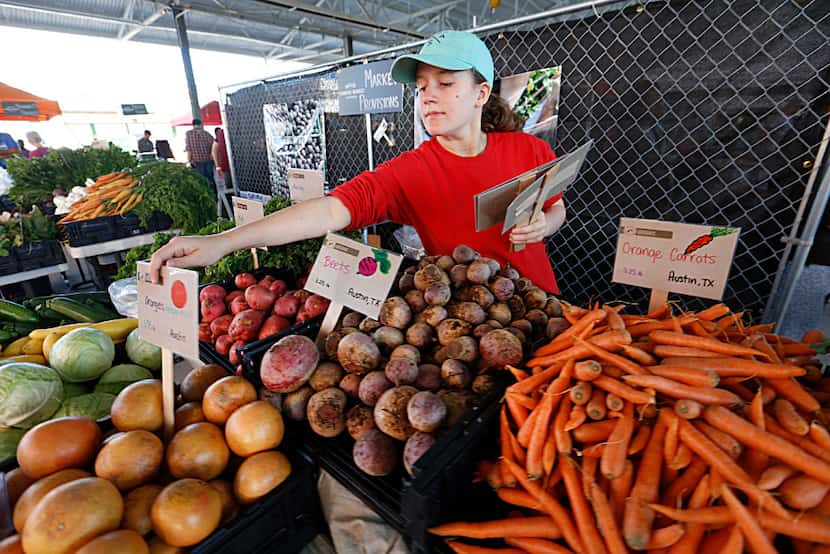 Josslyn Julka, 12, with Market Provisions places signs in each of the items offered for sale...