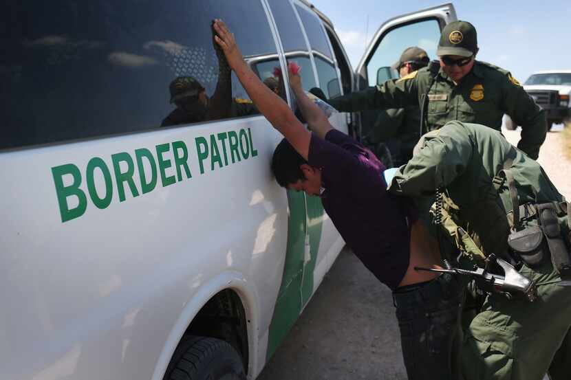 U.S. Border Patrol agents detain undocumented immigrants after they crossed the border from...