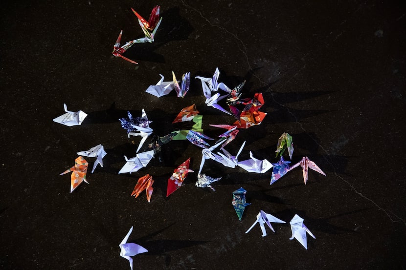 Origami cranes representing hope in Japanese culture are part of the casually sprawling set...