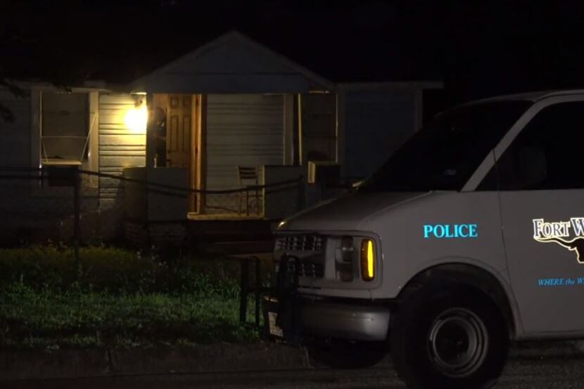 A Fort Worth police van sits outside a home where a man was injured in a stabbing Friday...