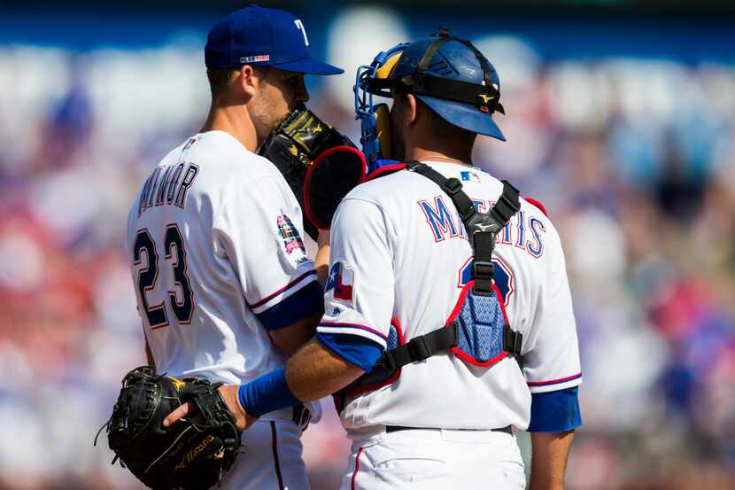 Texas Rangers starting pitcher Mike Minor (23) and catcher Jeff Mathis (2) conference on the...
