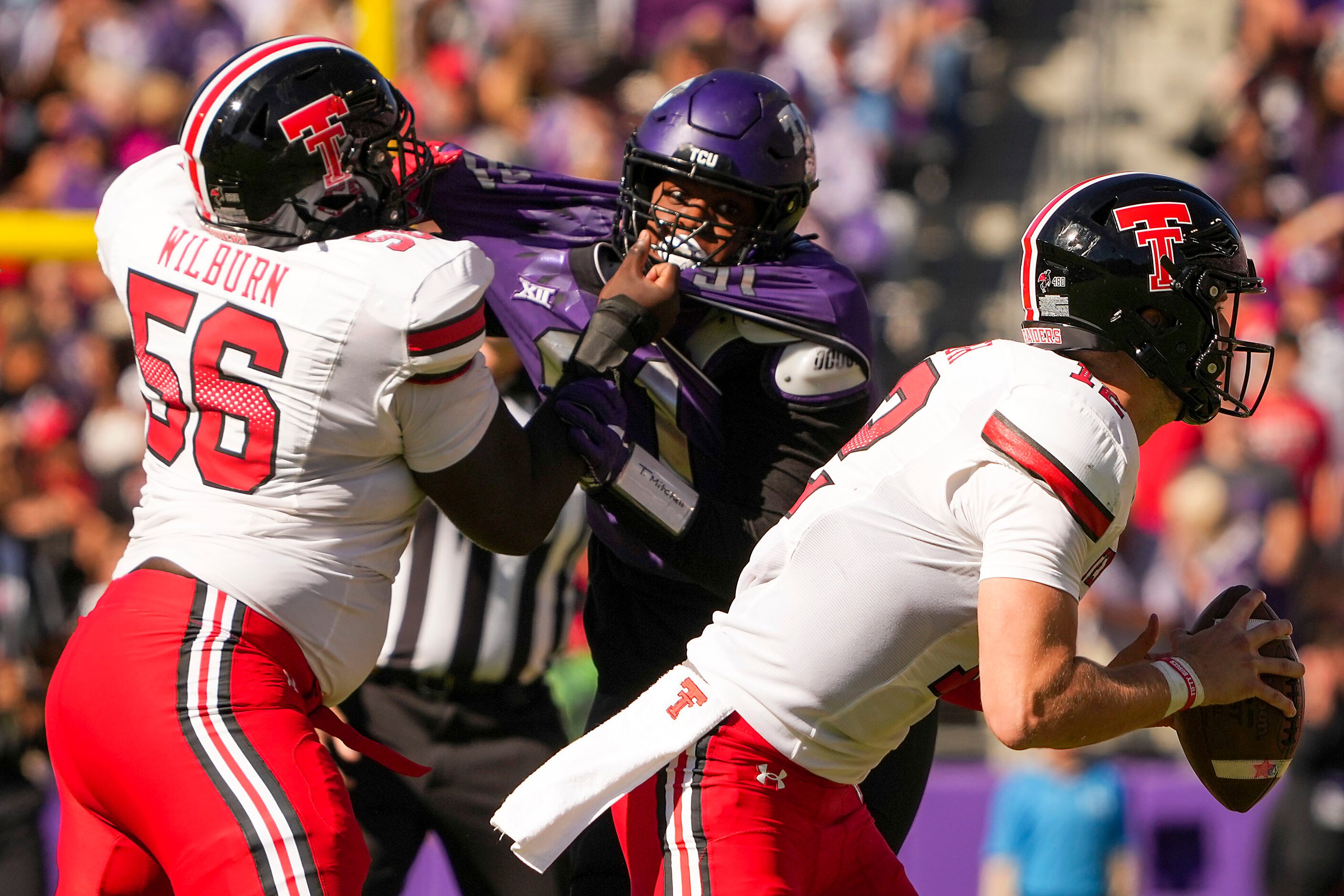 Texas Tech quarterback Tyler Shough (12) scrambles away from TCU defensive lineman Tymon...