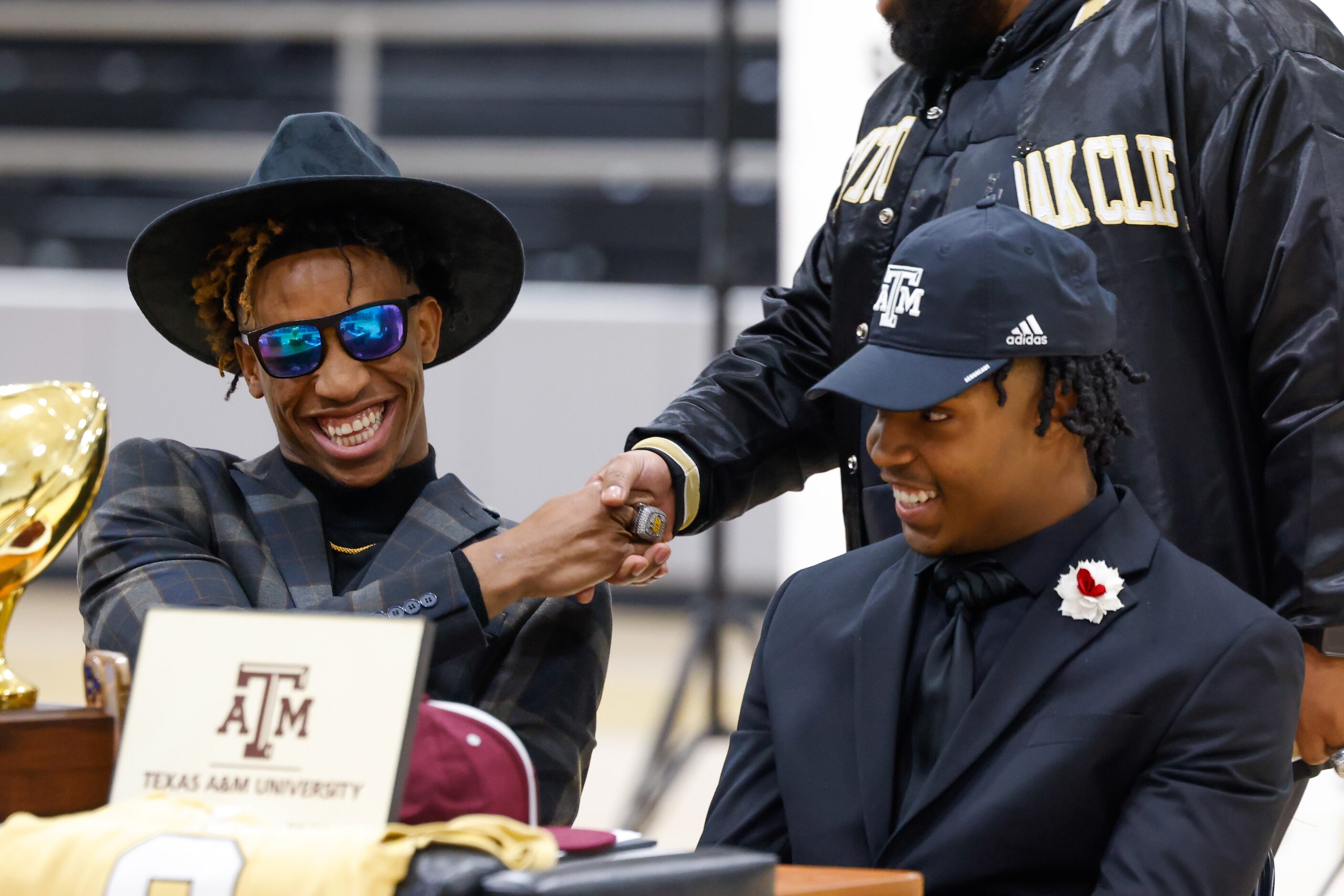 South Oak Cliff football player Manny (Malik) Muhammad (left) shakes hands with coach Ellis...