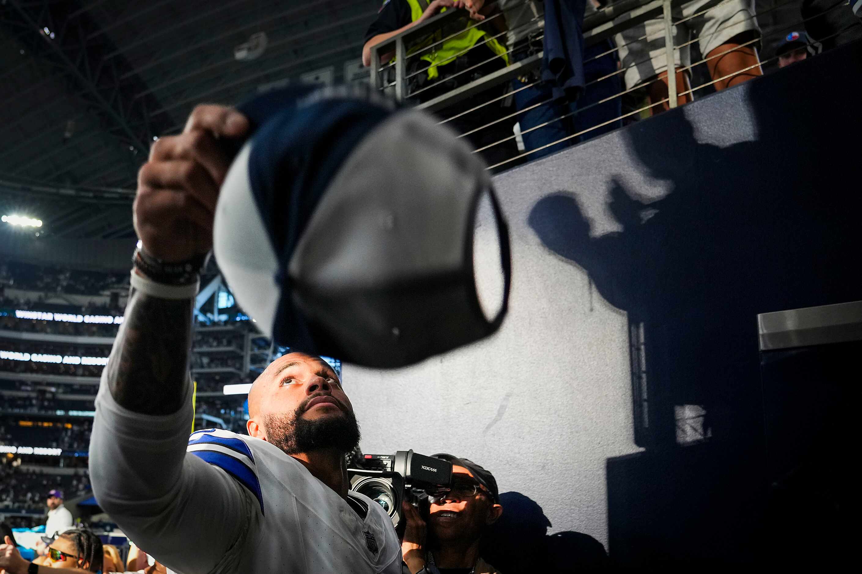 Dallas Cowboys quarterback Dak Prescott tosses his hat to the crowd after a victory over the...