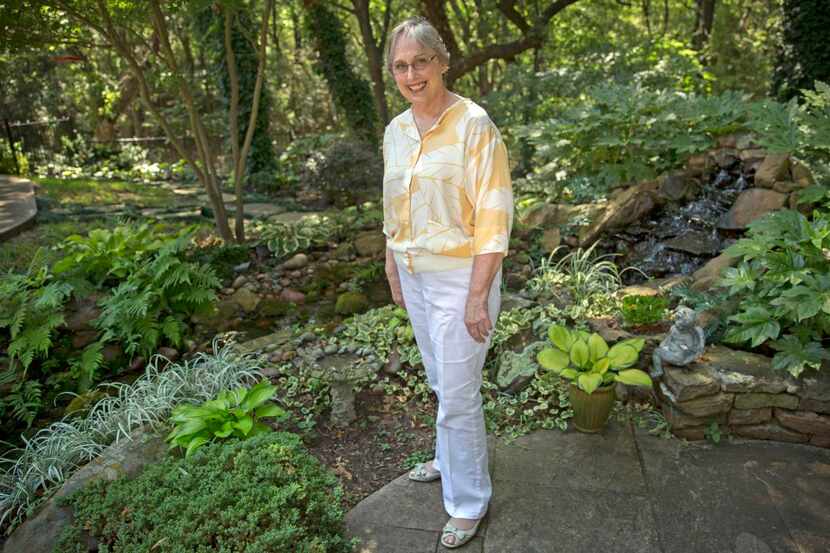 Diane McGee stands among hosta plants in her shade garden Monday, July 27, 2015 in Flower...