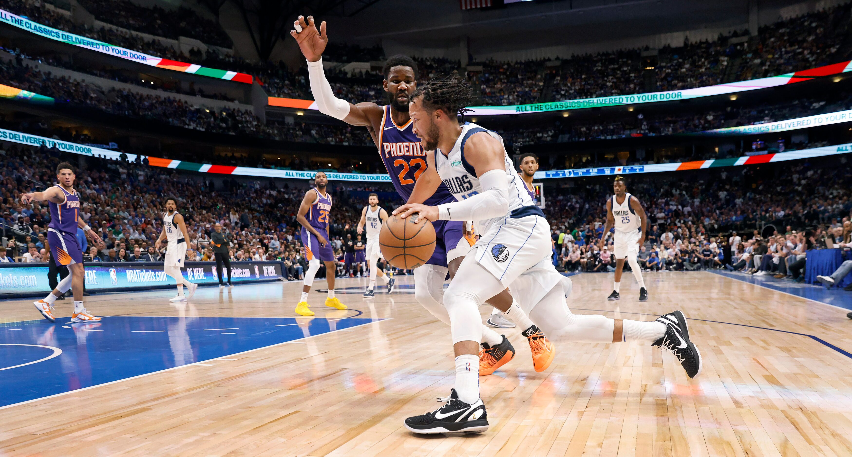 Dallas Mavericks guard Jalen Brunson (13) races past Phoenix Suns center Deandre Ayton (22)...