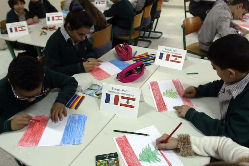 Children draw French and Lebanese flags at the Bahaa Al-Hariri school in the southern...