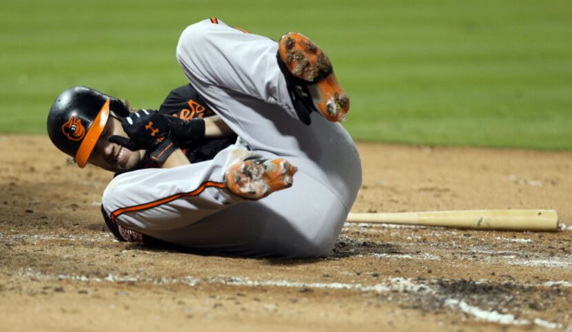 Baltimore Orioles first baseman Mark Reynolds (12) reacts after he is hit by a pitch from...