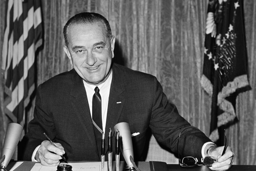 In this Aug. 10, 1964 file photo, President Lyndon B Johnson signs the Joint Resolution for...