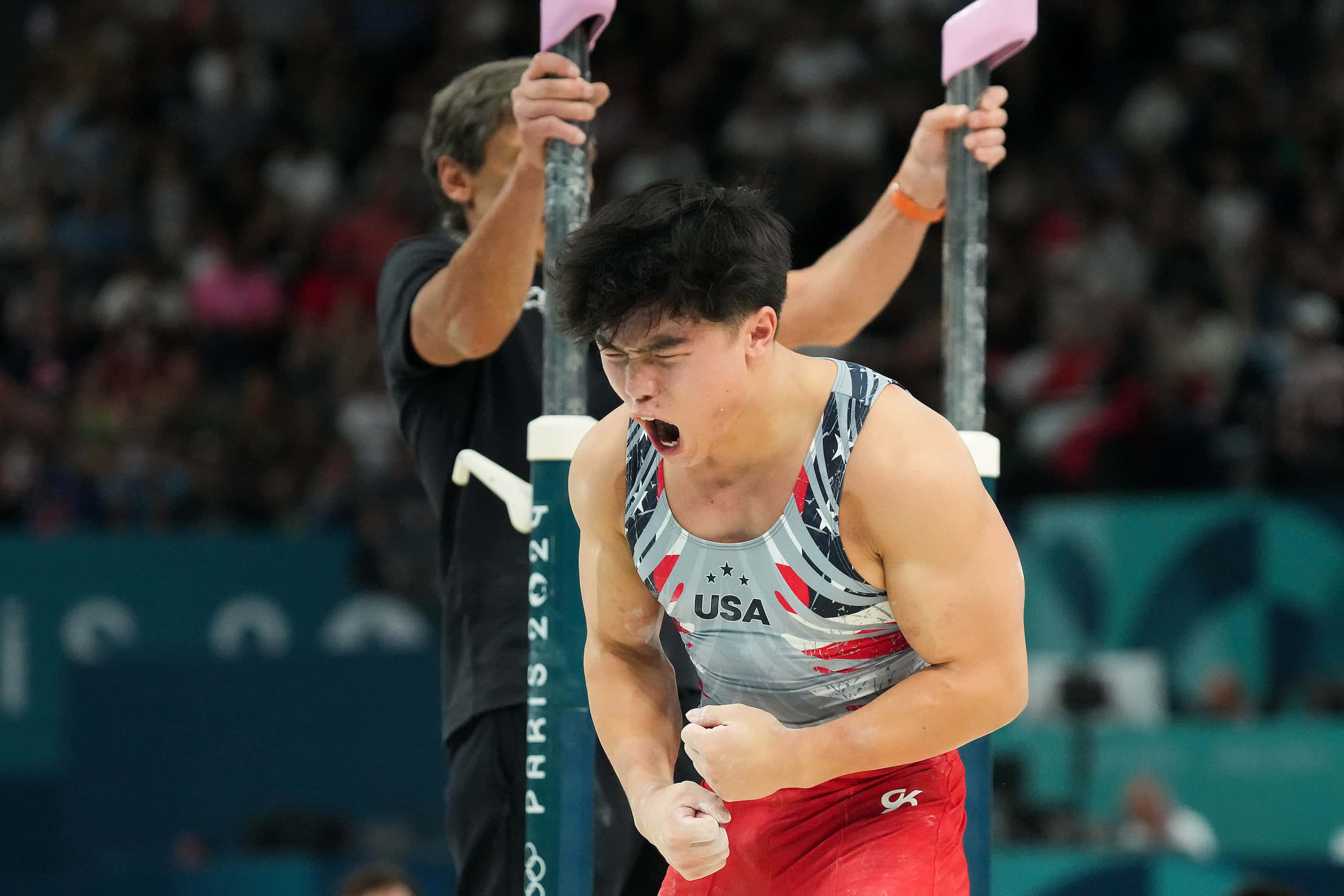Asher Hong of the United States reacts after competing on the parallel bars during the men’s...