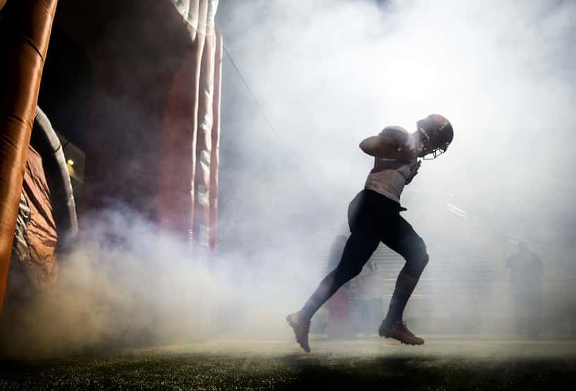 A Rockwall football player runs on the field before a District 11-6A high school football...