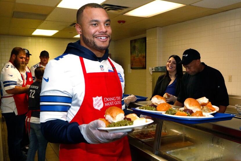 Dallas Cowboys quarterback Dak Prescott (4) serves early Thanksgiving Day dinners along with...