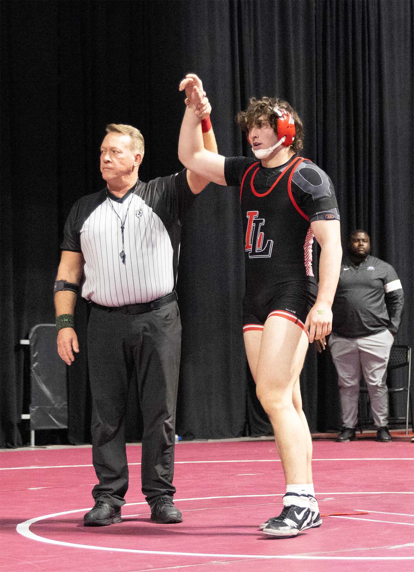 An official raises the hand of Payton Pierce from Lovejoy after defeating Jack Ashley from...