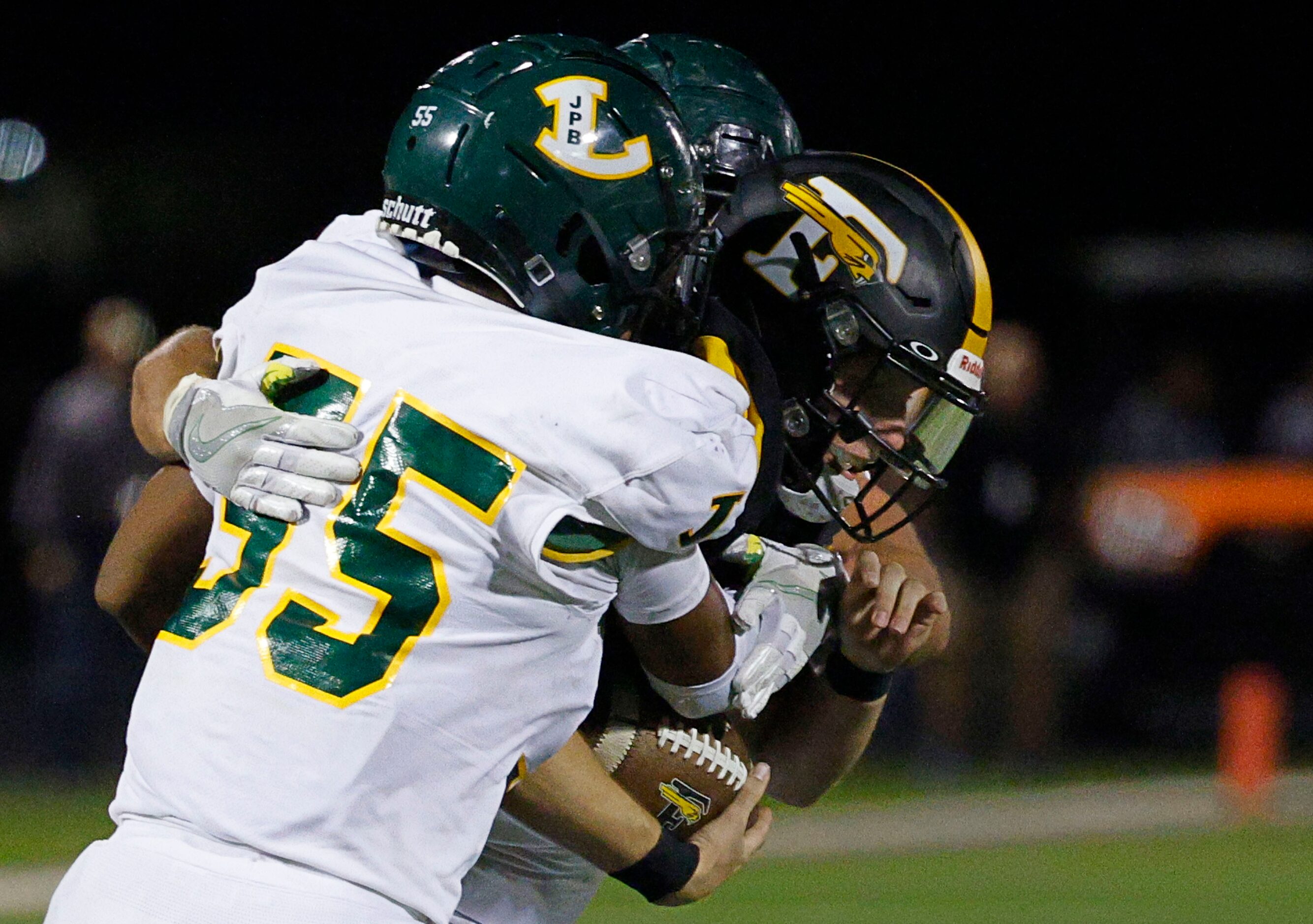 Forney's quarterback Kyle Crawford (3), right, is sacked by Longview's Xaryus Sheppard (55)...