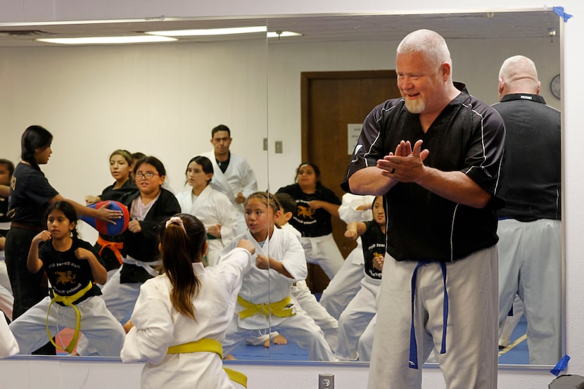 Conrad football coach Josh Ragsdale cheers on students in a beginner’s class at the 9th...