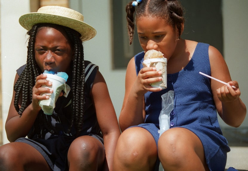 Paulette Dixon (left) and her  friend Cassandra Calhoun cool off with snow cones after...