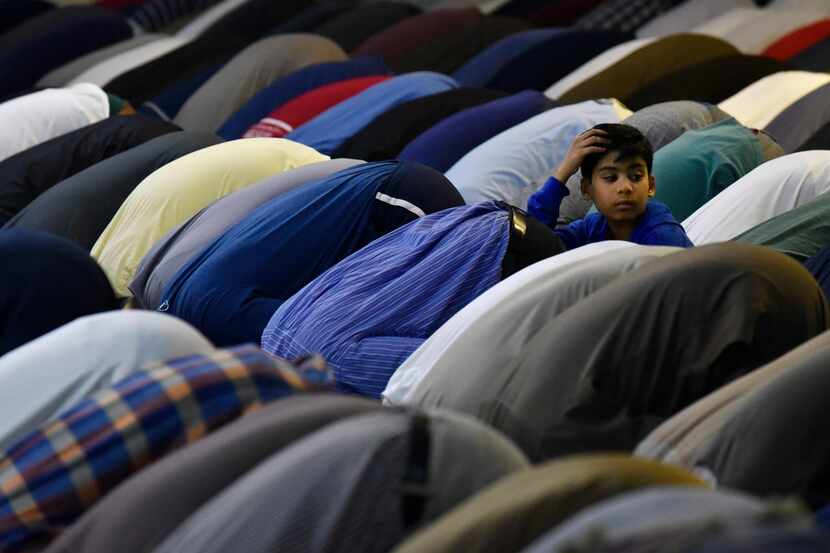 A young boy watched as other Muslims prayed for Ramadan at the Valley Ranch Islamic Center...